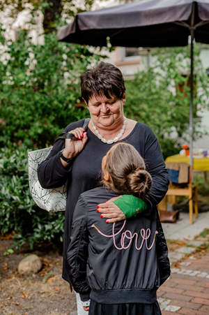 Frau legt Arm um Kind